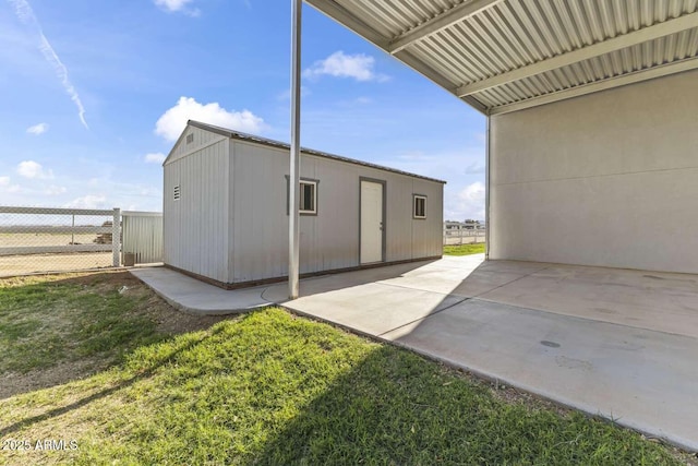 exterior space featuring an outbuilding, fence, a yard, and a patio area
