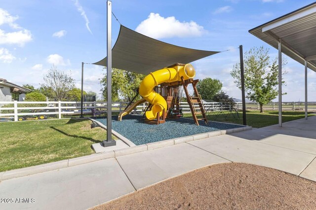 community play area featuring a yard and fence