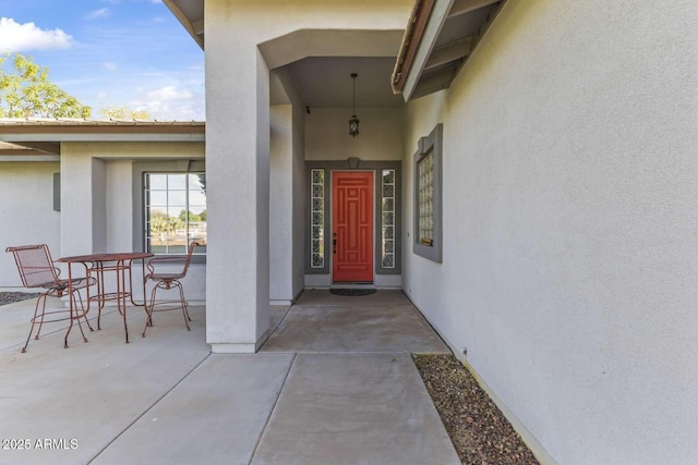 doorway to property featuring a patio area and stucco siding