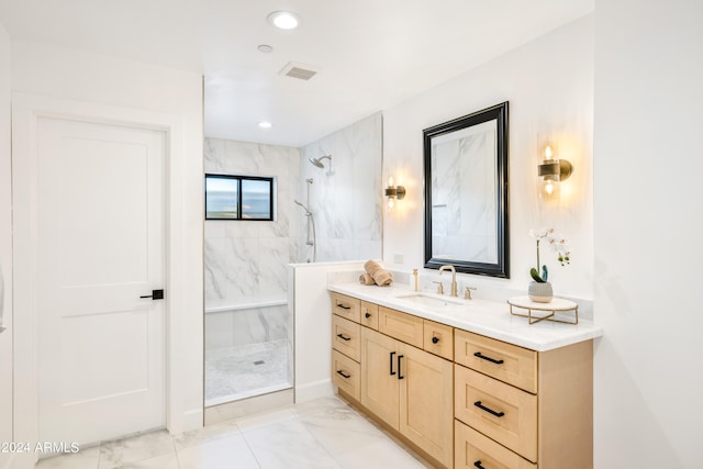 bathroom with vanity and a tile shower