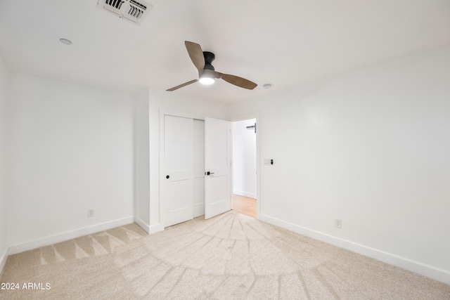 unfurnished bedroom with a closet, ceiling fan, and light colored carpet