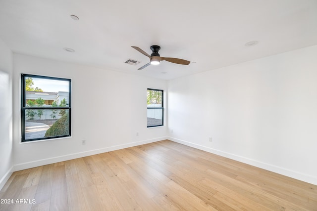 unfurnished room featuring light hardwood / wood-style floors, a healthy amount of sunlight, and ceiling fan