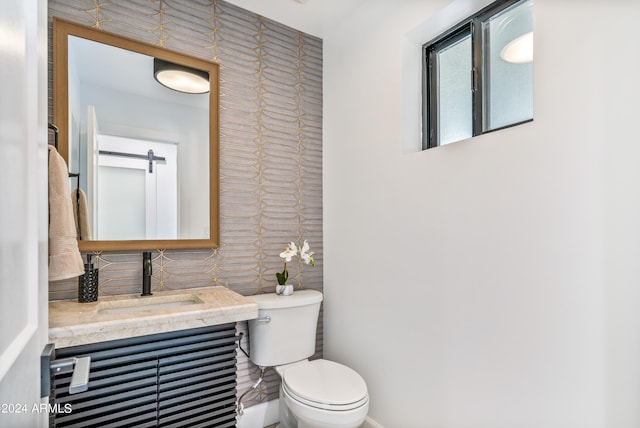 bathroom featuring vanity, toilet, and tasteful backsplash