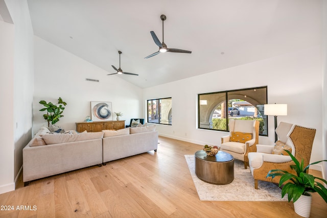 living room featuring ceiling fan, high vaulted ceiling, and light hardwood / wood-style flooring