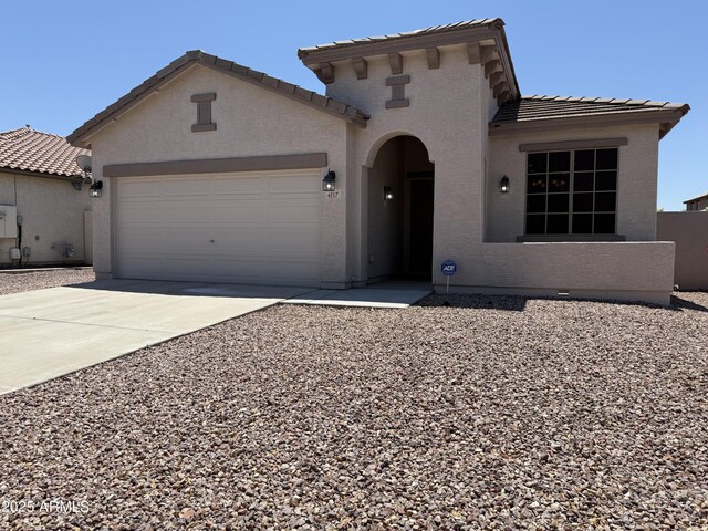 4117 W Allen St, Laveen, AZ 85339 - mediterranean / spanish home featuring a tile roof, an attached garage, concrete driveway, and stucco siding