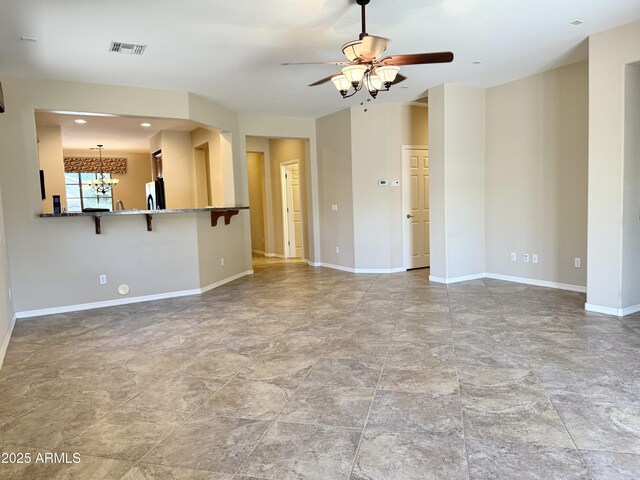 4117 W Allen St, Laveen, AZ 85339 - unfurnished living room with ceiling fan, a chandelier, baseboards, and stone finish floors