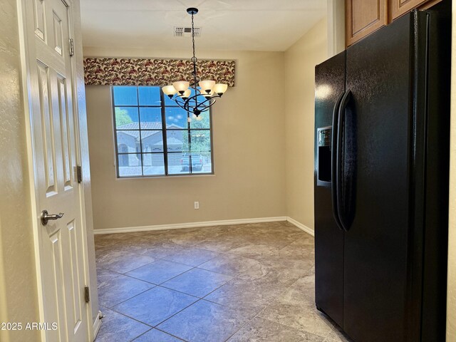 4117 W Allen St, Laveen, AZ 85339 - kitchen with black fridge, a chandelier, pendant lighting, and baseboards