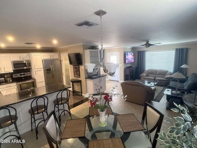 dining room featuring light tile patterned floors, ceiling fan, and ornamental molding