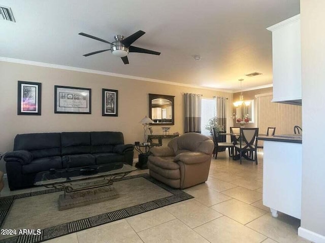 living room featuring crown molding, light tile patterned flooring, and ceiling fan with notable chandelier