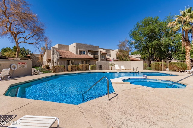 community pool featuring a patio, fence, and a hot tub