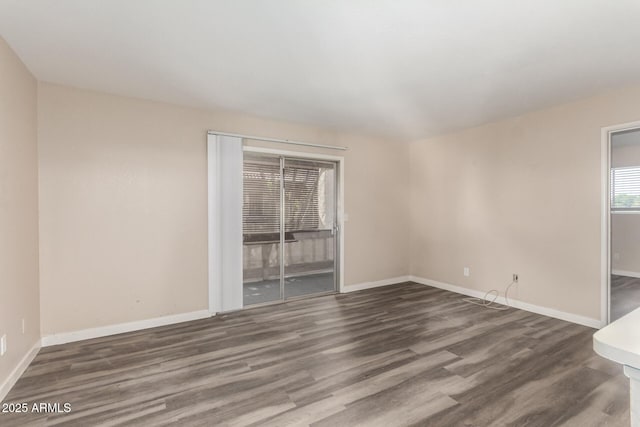 unfurnished room featuring baseboards and wood finished floors