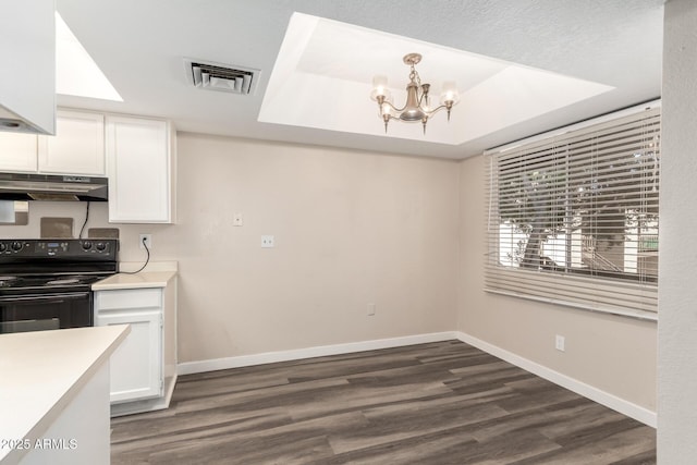 kitchen with under cabinet range hood, visible vents, white cabinetry, black electric range oven, and a raised ceiling