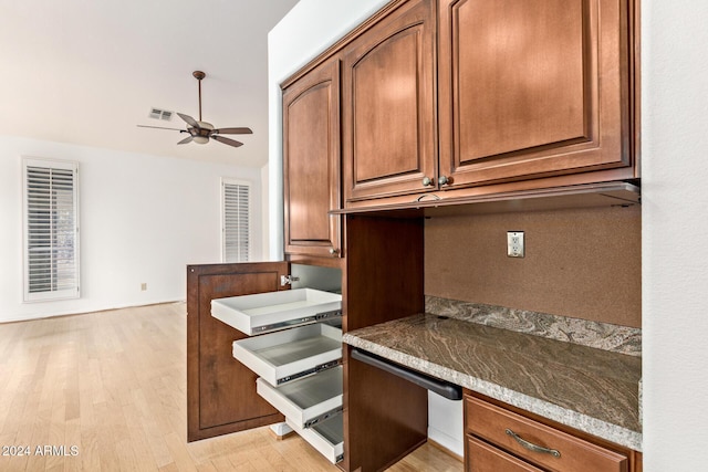 kitchen with ceiling fan, light wood-type flooring, built in desk, and vaulted ceiling