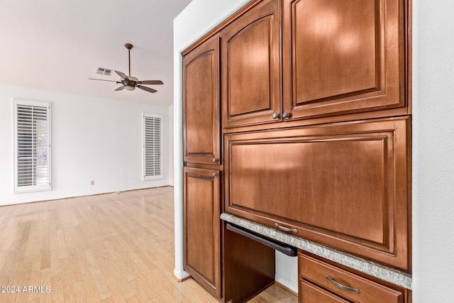 interior space with ceiling fan, built in desk, and hardwood / wood-style flooring