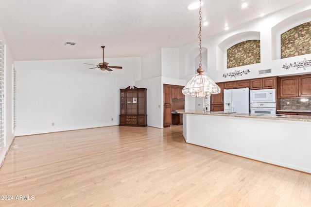 kitchen featuring decorative backsplash, white appliances, ceiling fan with notable chandelier, pendant lighting, and high vaulted ceiling