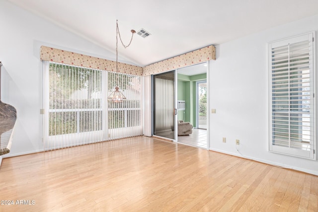 unfurnished dining area featuring wood-type flooring and lofted ceiling