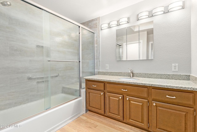 bathroom featuring vanity, bath / shower combo with glass door, and wood-type flooring