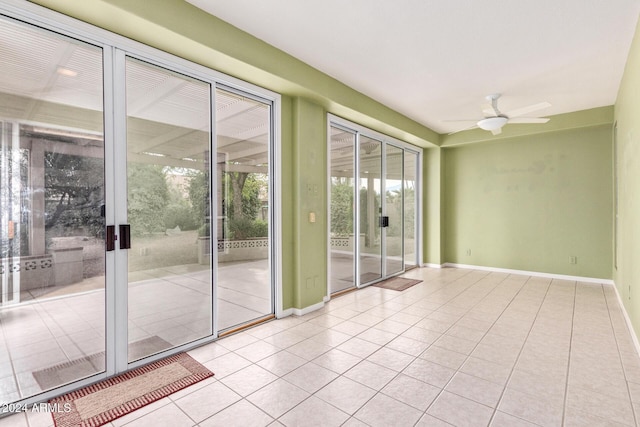 tiled empty room featuring ceiling fan