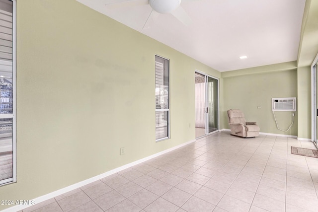 unfurnished room featuring a wall mounted air conditioner, ceiling fan, and light tile patterned flooring