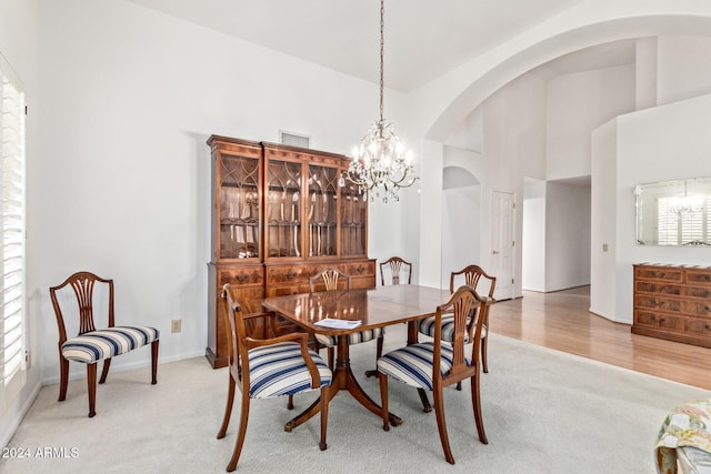 dining room featuring carpet floors, high vaulted ceiling, an inviting chandelier, and a wealth of natural light