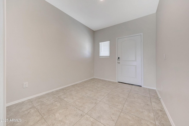 unfurnished room featuring light tile patterned flooring and baseboards