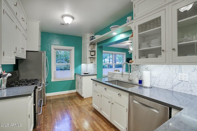 kitchen featuring sink, white cabinetry, stainless steel appliances, and tasteful backsplash