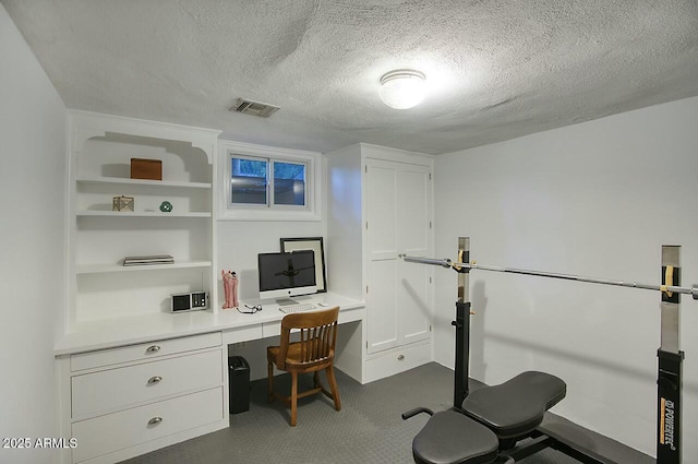 office area with a textured ceiling and built in desk