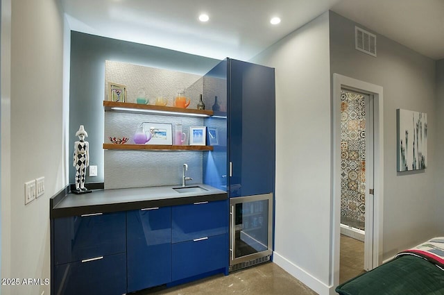 bar featuring wine cooler, blue cabinets, and sink