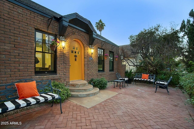 view of exterior entry featuring a patio area