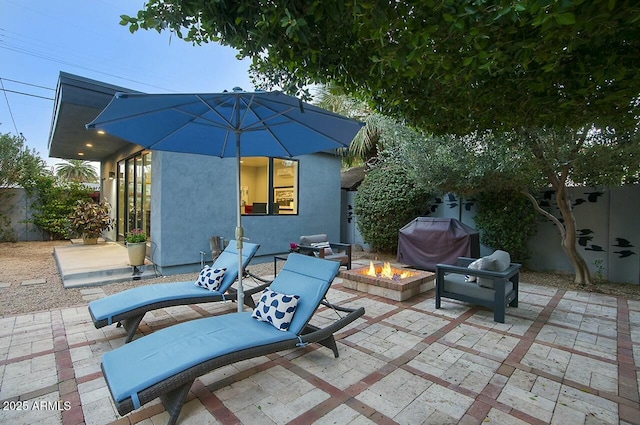 view of patio / terrace with an outdoor fire pit and a grill