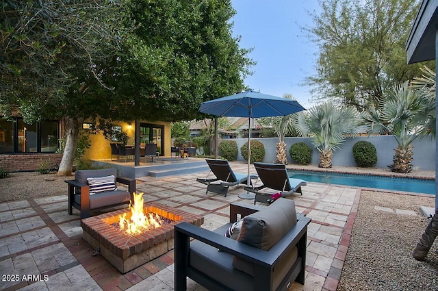 view of patio / terrace featuring a fenced in pool and an outdoor fire pit