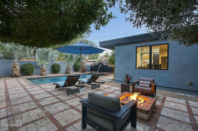 view of patio / terrace with a fenced in pool and an outdoor fire pit