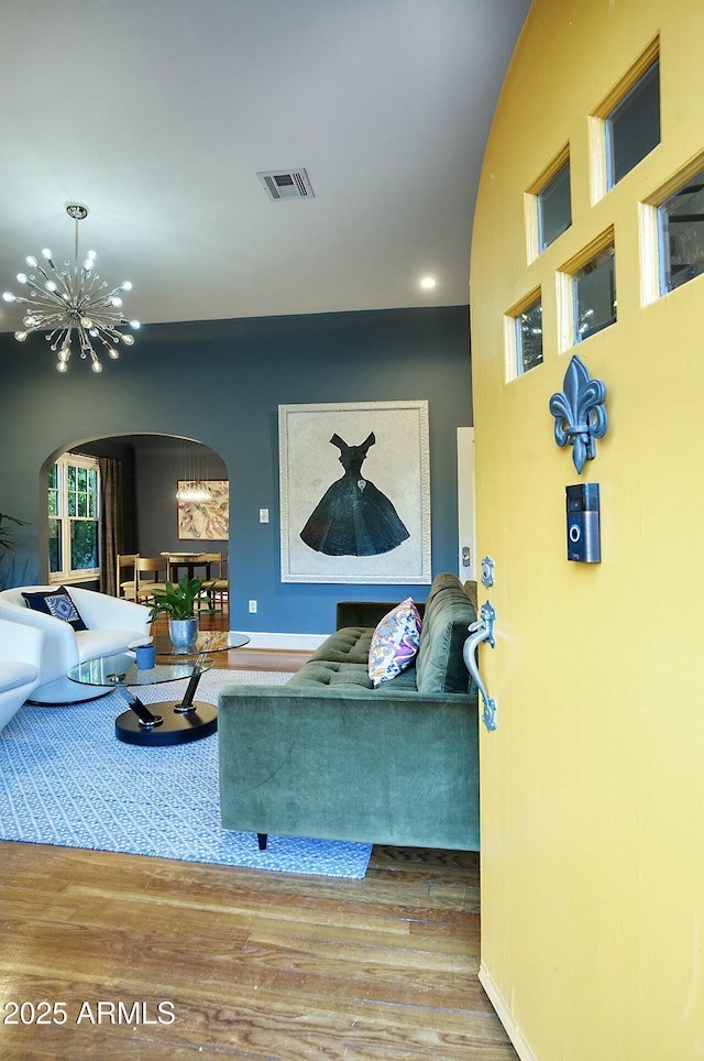 living room featuring an inviting chandelier and hardwood / wood-style floors