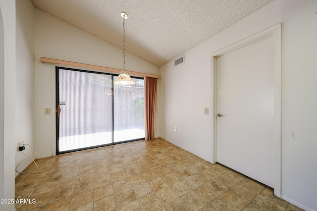 unfurnished dining area featuring visible vents, stone finish flooring, a textured ceiling, and lofted ceiling