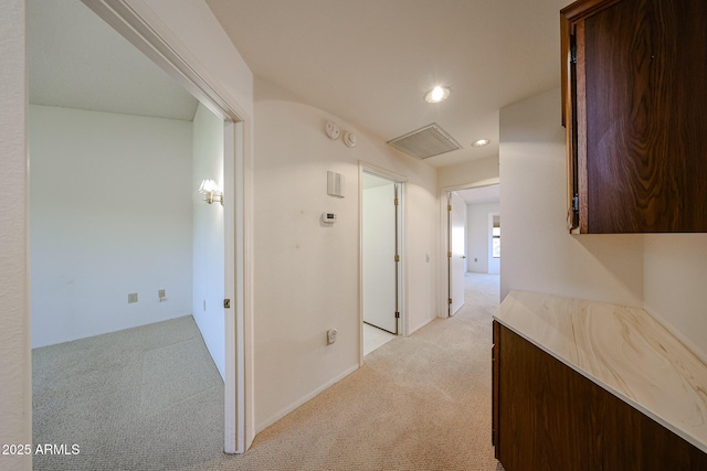 hallway featuring visible vents, recessed lighting, and light colored carpet