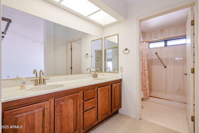 bathroom featuring a shower with shower curtain, toilet, a sink, and double vanity