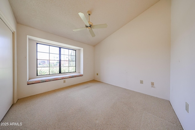 carpeted spare room featuring ceiling fan and vaulted ceiling