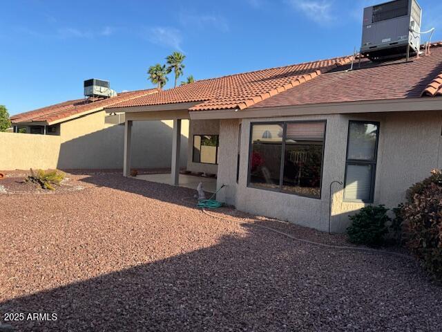 back of property with a patio, stucco siding, a tile roof, and cooling unit