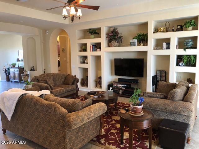 35401 N Via Tramonto St, Phoenix, AZ 85086 - living room with built in features, arched walkways, and a ceiling fan