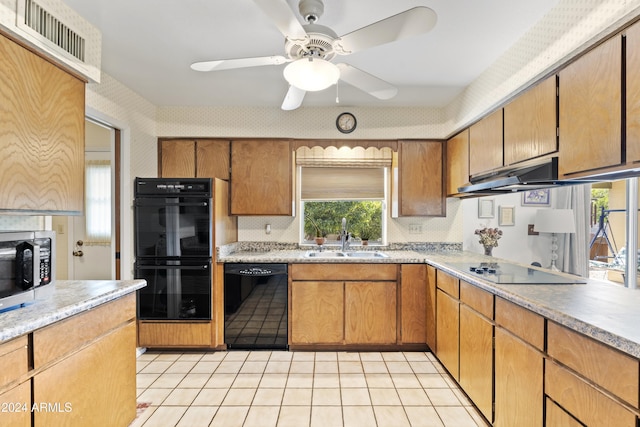 kitchen with a ceiling fan, a sink, light countertops, black appliances, and under cabinet range hood