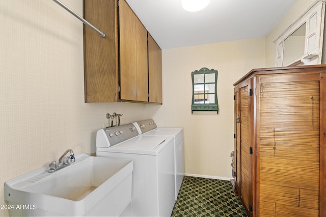 washroom featuring a sink, baseboards, cabinet space, and washer and dryer