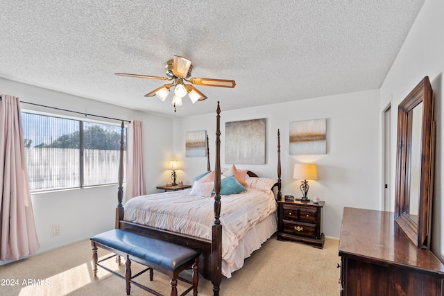 bedroom with light colored carpet, ceiling fan, and a textured ceiling