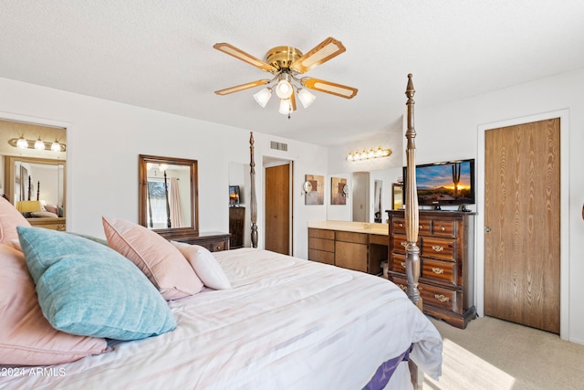 bedroom featuring light carpet, a textured ceiling, connected bathroom, and visible vents