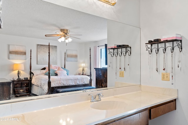 bathroom with ceiling fan, a textured ceiling, and vanity