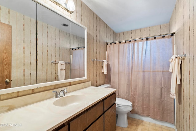 bathroom with shower / bathtub combination with curtain, wood walls, vanity, and toilet