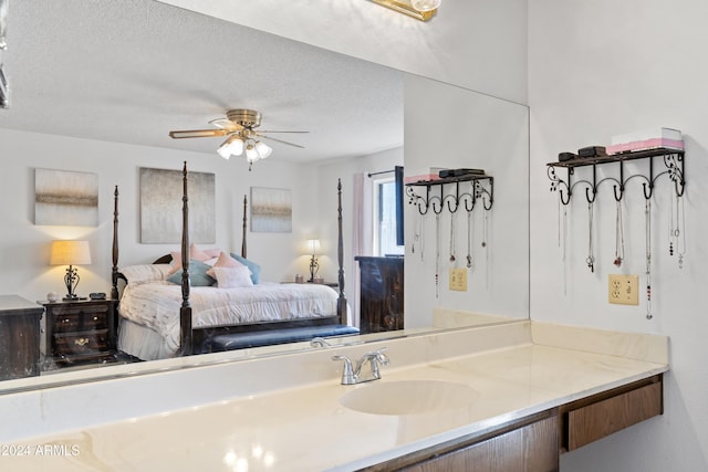 ensuite bathroom featuring vanity, ceiling fan, a textured ceiling, and connected bathroom