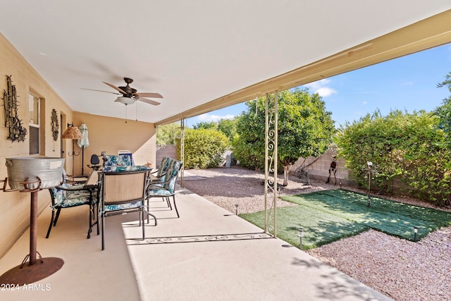 view of patio featuring ceiling fan, a fenced backyard, and outdoor dining space