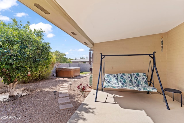 view of patio / terrace with a hot tub and a fenced backyard