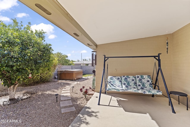view of patio / terrace with fence and a hot tub