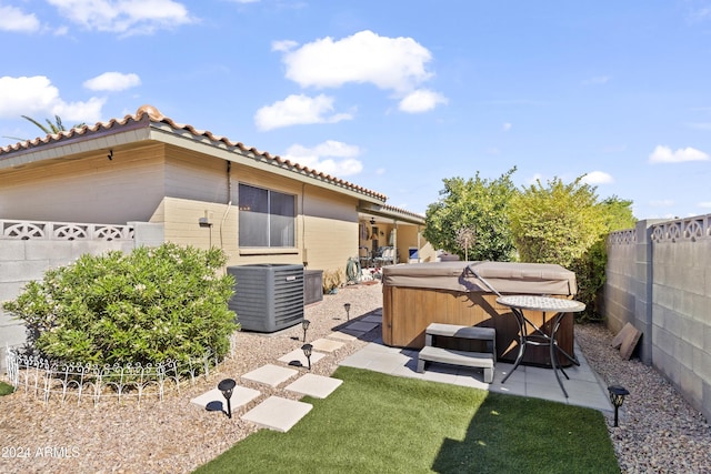 view of yard featuring a patio area, a fenced backyard, a hot tub, and central AC